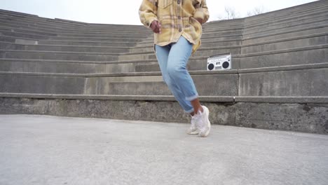 anonymous black woman dancing on steps in park