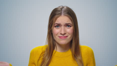 portrait of stressed attractive woman waving head no on grey background.