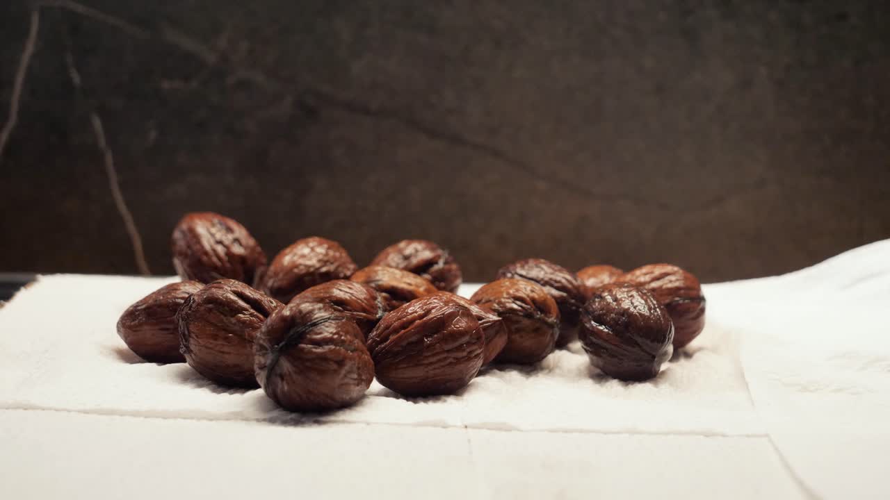 Putting wet walnuts on paper towel, static close up
