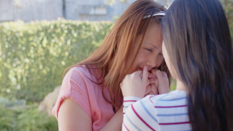 asian mother and daughter bonding outdoors, holding hands and smiling at each other