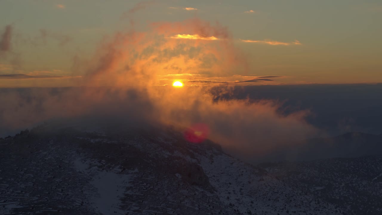 antena - puesta de sol colorida detrás de las nubes sobre una montaña nevada - filmada en dji inspire 2 x7 50 mm raw