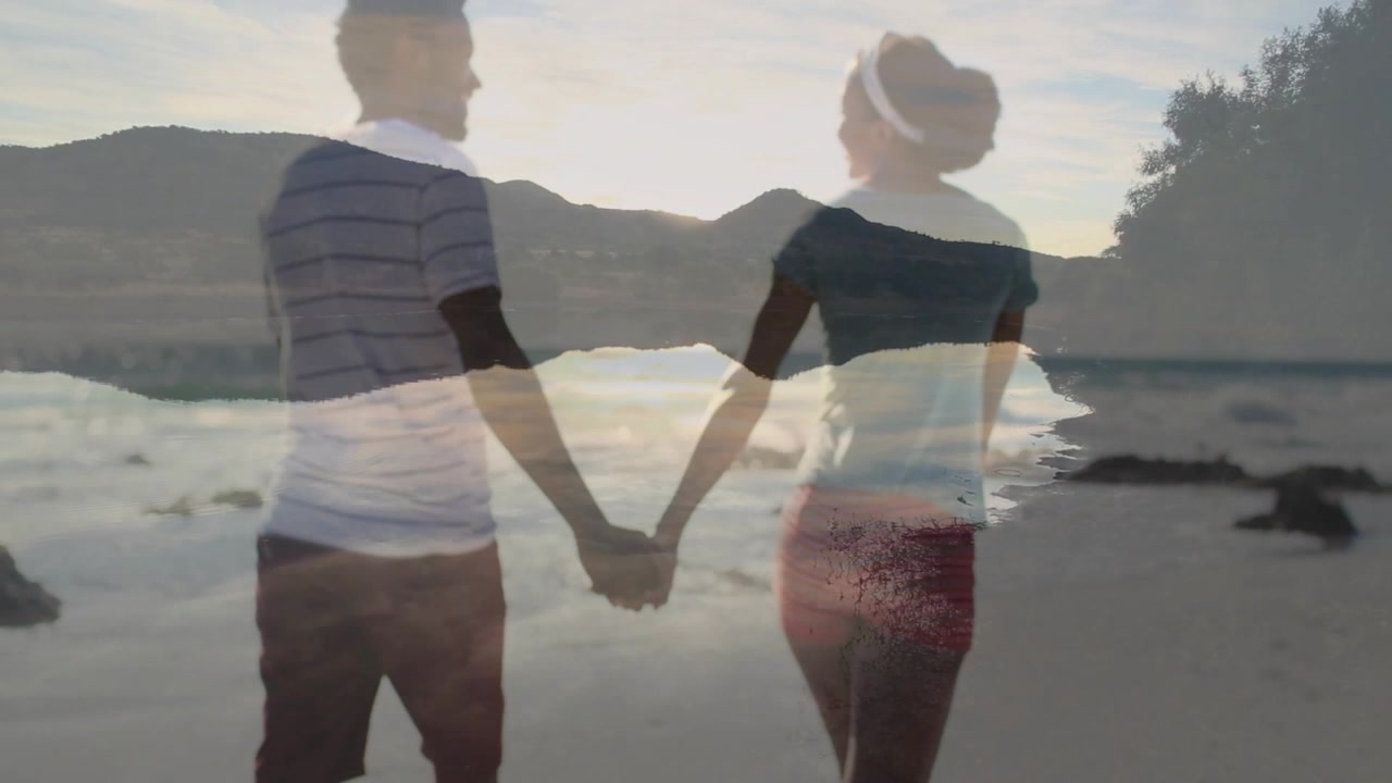 Couple holding hands on beach, stepping toward sun as waves overlaying duo for design