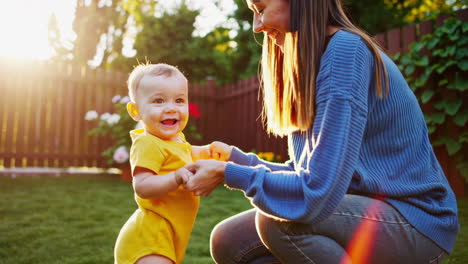 mother and baby learning to walk in a garden