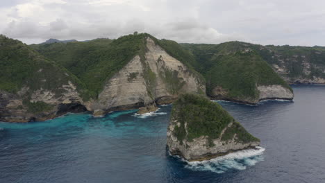 Coast-line-of-Nusa-Penida-with-huge-cliffs-and-ocean-waves-crushing-ashore,-Bali,-Indonesia