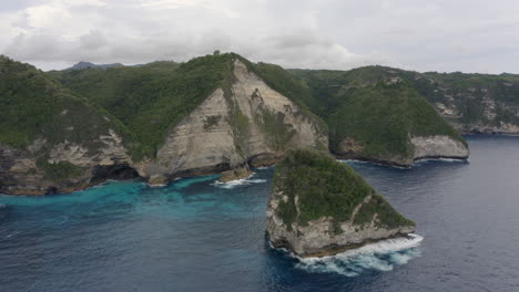 coast line of nusa penida with huge cliffs and ocean waves crushing ashore, bali, indonesia