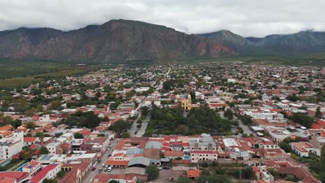 Luftaufnahme-Einer-Drohne-Mit-Wohnhäusern-In-Der-Stadt-Cafayate,-Salta,-Argentinien,-Südamerika,-Mit-Hügeln-Im-Hintergrund