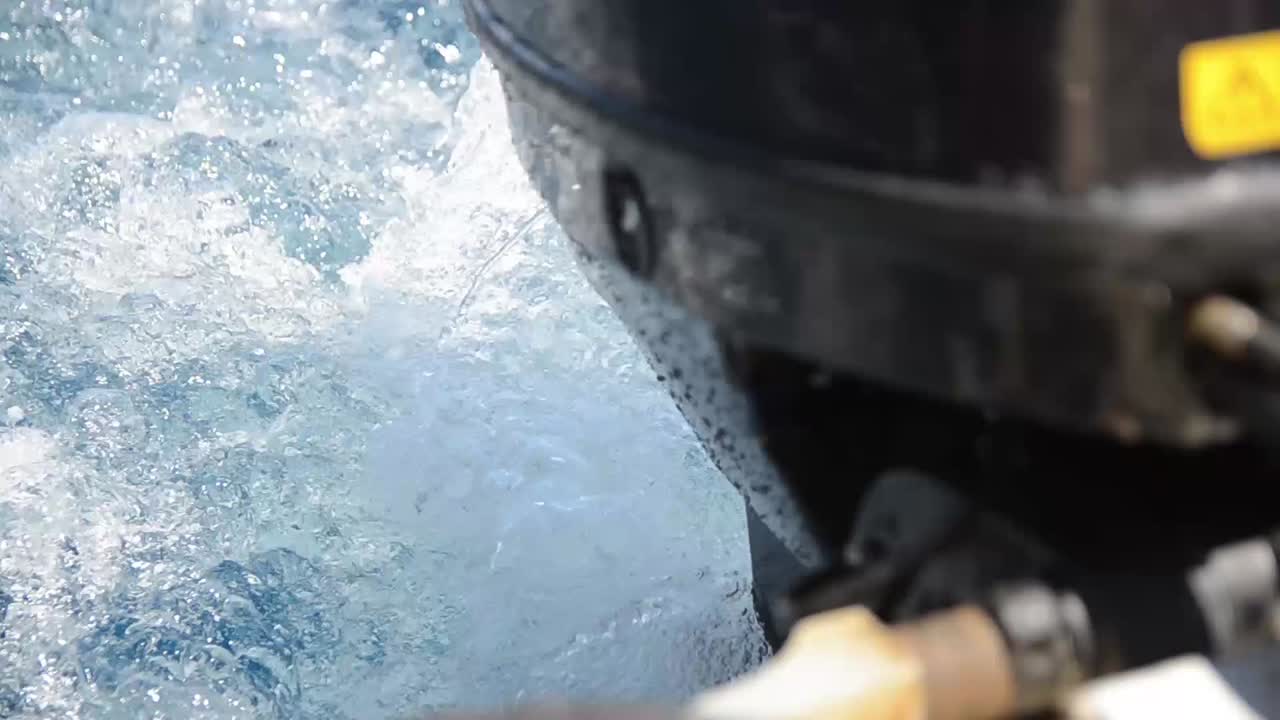 Outboard motor on boat driving on water close up