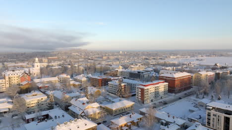 aerial view of snowy rooftops in the city of kuopio, golden hour in finland