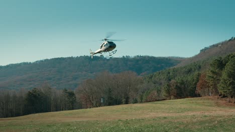 a helicopter comes in for a landing in slow motion in a field