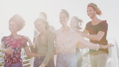 Gruppe-Junger-Freunde-Im-Freien,-Die-Gemeinsam-über-Die-Brücke-Gehen,-Gegen-Die-Flackernde-Sonne