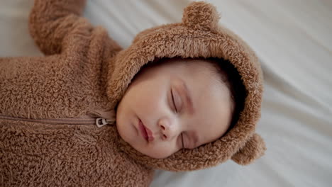 adorable baby sleeping in a bear costume