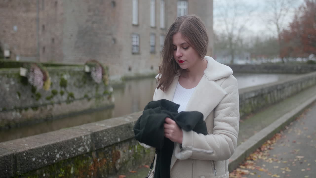 красивая молодая блондинка снимает черный шарф и надевает его обратно-1