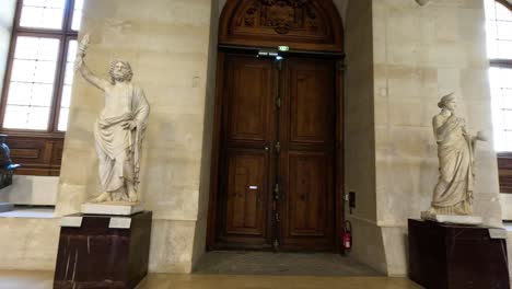 visitors and statues in louvre museum, paris