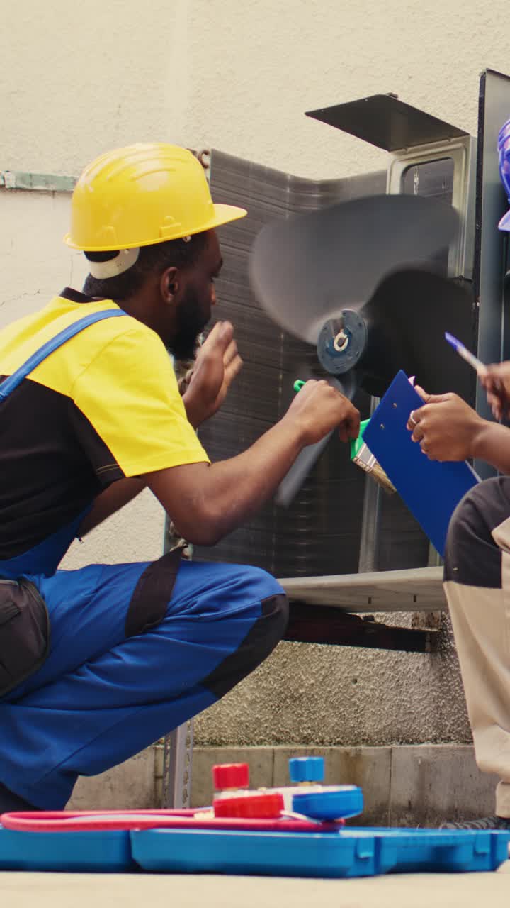 Vertical video Worker sweeps debris in air conditioner