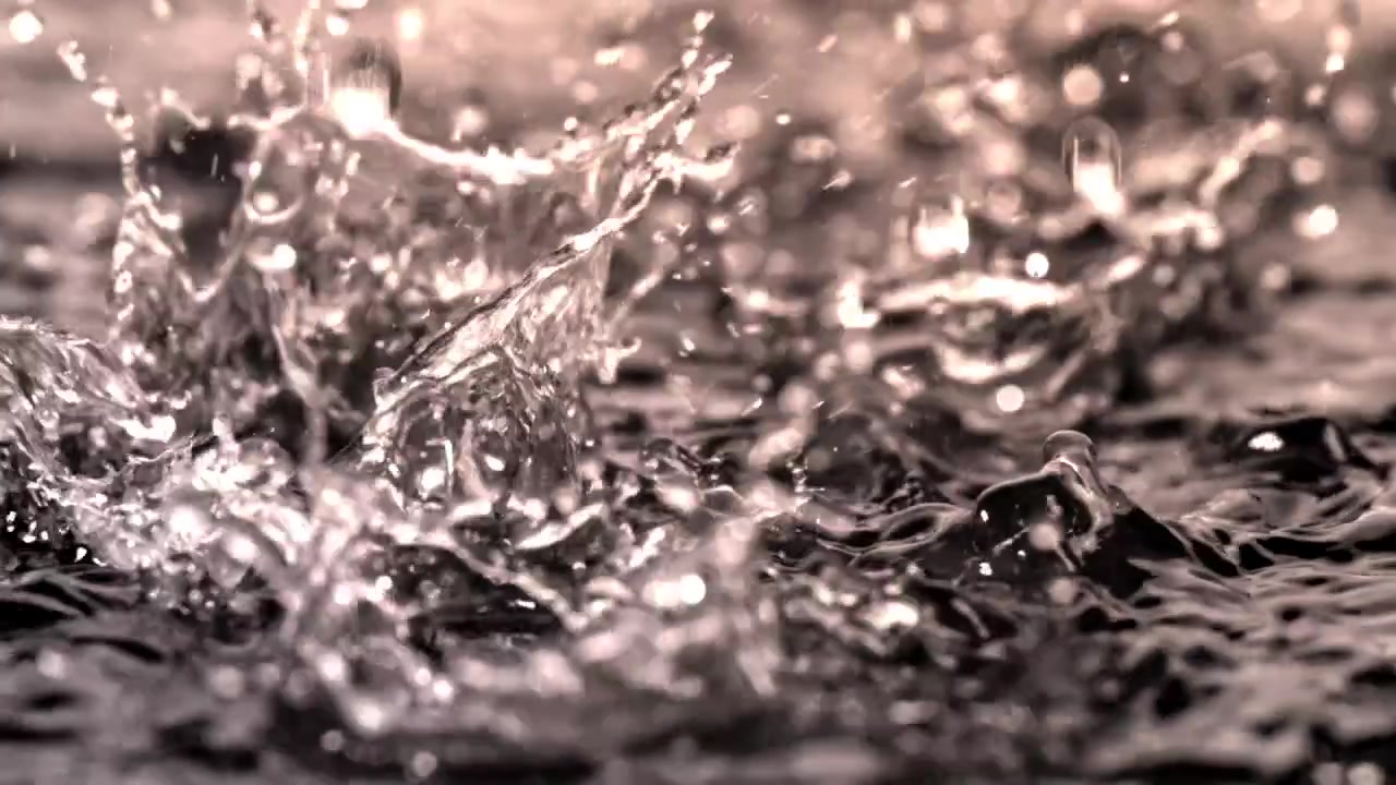 Close-up of Rain Droplets Splashing on Water Surface