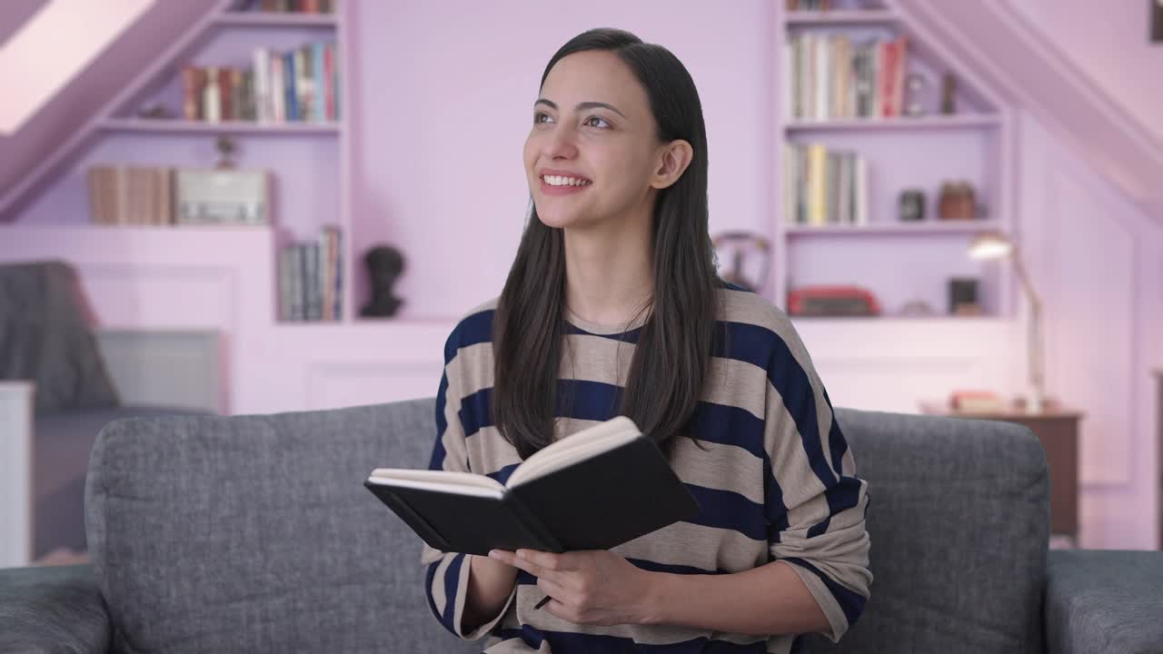 una chica india feliz y linda escribiendo un libro