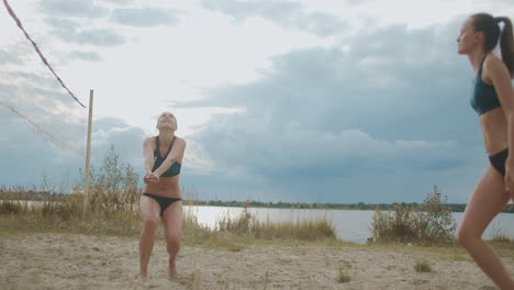 Sportliche-Frauen-Spielen-Beachvolleyball-Im-Sommer-In-Zeitlupe,-Aufgenommen-Tagsüber-Gegen-Bewölkten-Himmel