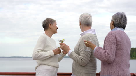 three lovely serior women dancing and taking selfies while they have a drinks