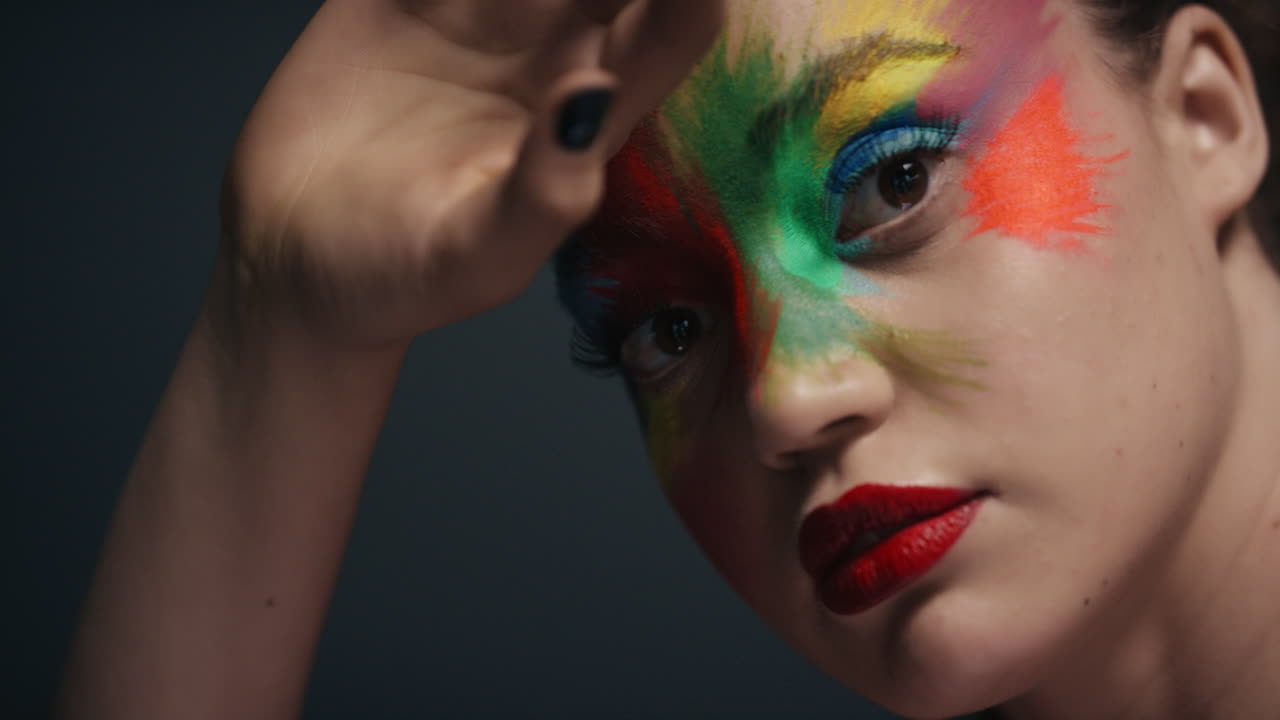 retrato de cerca mujer atractiva con cara pintada de colores exótico arte corporal multicolor sensual mujer que disfruta de la expresión creativa