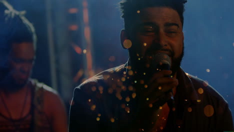 singer holding mic and guitarist playing guitar under concert lights, with floating spark particles
