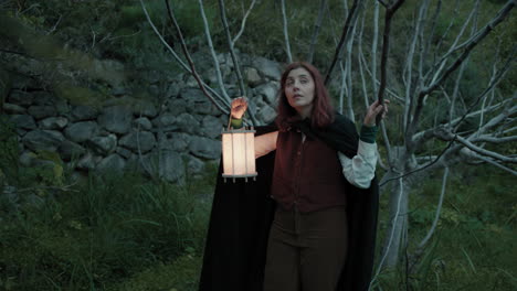 scared woman runs away into the fairytale forest with a lantern at night