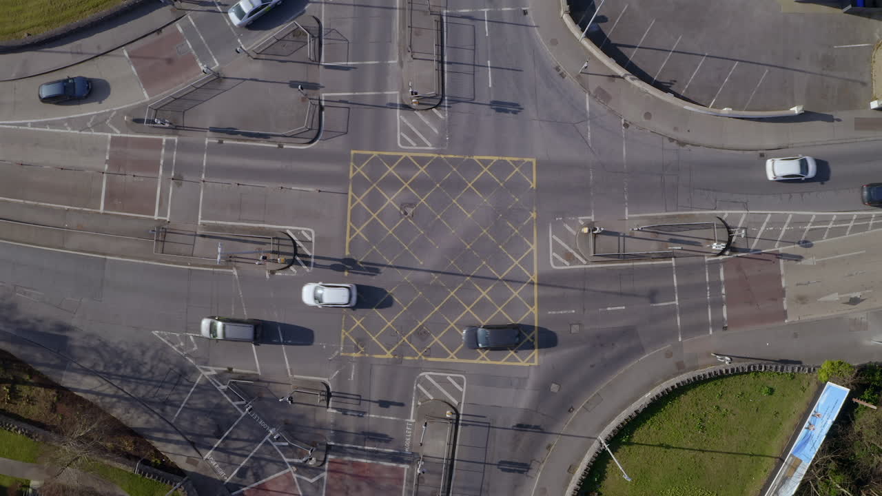 Aerial top-down view of a major four way intersection, pulling up to reveal the city's road network