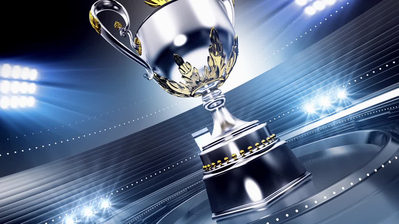 Trofeo d'argento e d'oro rotante in un'arena dello stadio illuminata dai riflettori