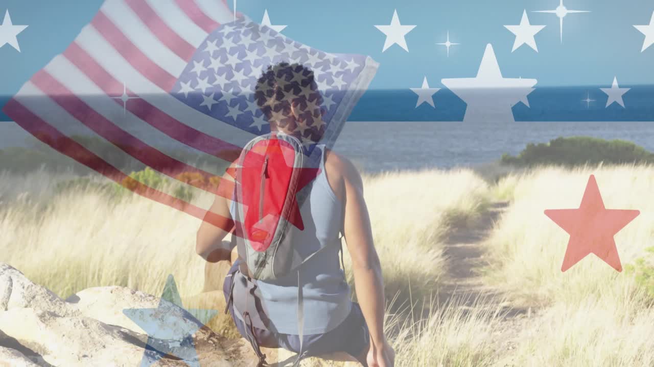 animación de la bandera estadounidense sobre un hombre afroamericano sentado en las montañas