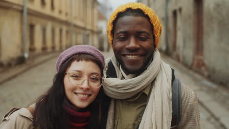 portrait of happy multiethnic couple in old town