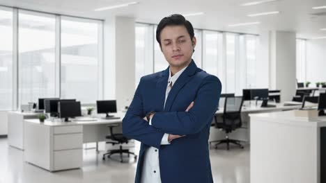 portrait of confident indian businessman standing crossed hands