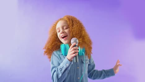 fotografía de estudio de una chica con auriculares cantando karaoke en el micrófono contra un fondo púrpura - tomada en cámara lenta
