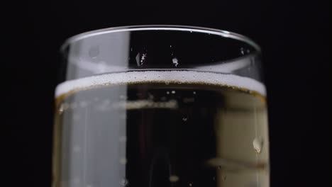 bubbles of a sparkling drink rise up the glass black background close up bubbles of a sparkling drink rise up the glass a close up shot of a glass of champagne black background