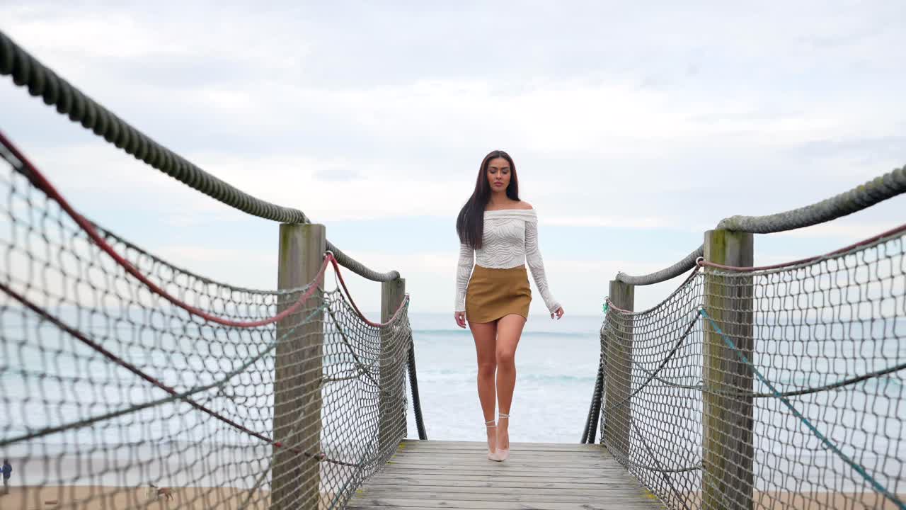 Woman walking on a wooden bridge at the beach