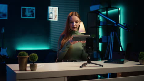 niña grabando una revisión de altavoz portátil usando la cámara de su teléfono inteligente