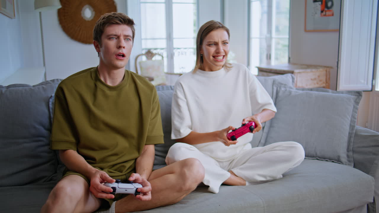 Video gaming teenagers playing together sitting apartment. Videogame competition