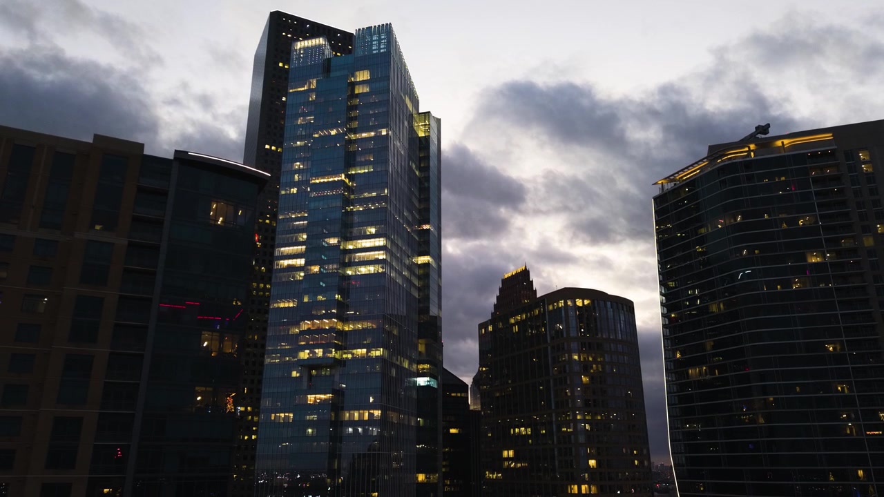Ripresa drone inversa dal basso dell'edificio illuminato Texas Tower a Houston, al tramonto