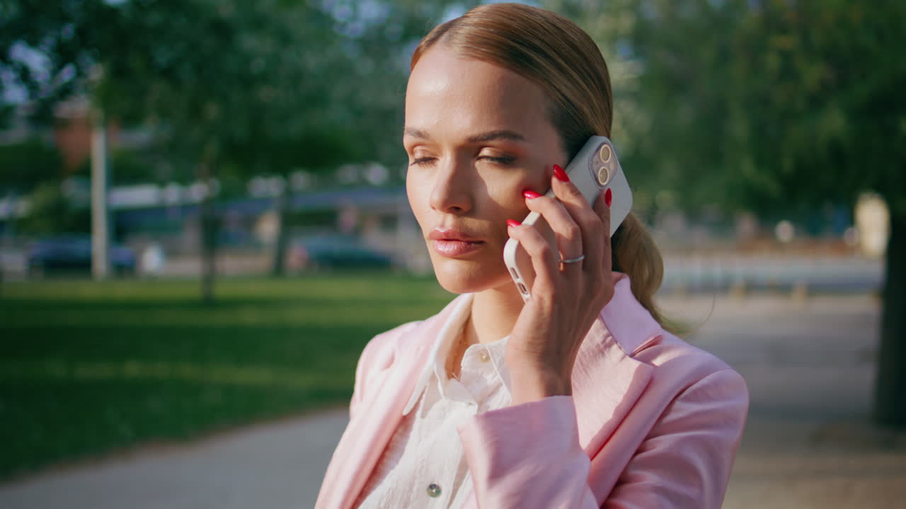 똑똑한 사업가 여성이 전화에 응답하고 서 있는 니 스트리트 근처에서.