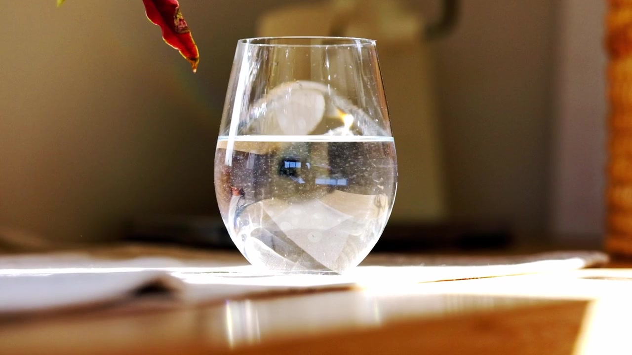Ett glas vatten med virvlande orenheter och luftbubblor.