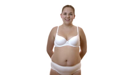 smiling overweight woman in white underwear on white studio background