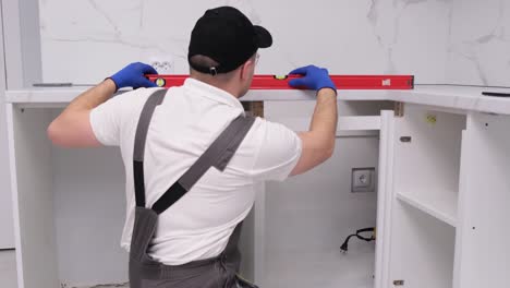 a master in uniform installs furniture using a construction level installation of accessories a master in uniform installs furniture using a construction level installation of accessories