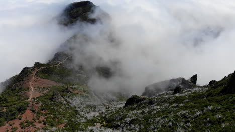 The-drone-captures-the-stunning-landscape-of-Pico-Ruivo-on-Madeira,-showcasing-rugged-mountains,-lush-greenery,-and-winding-trails-that-lead-to-breathtaking-panoramic-views