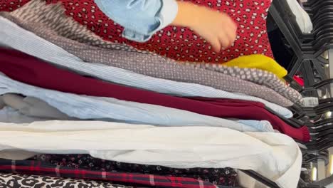 a girl in a vintage shop a young girl chooses things on a hanger in a store second hand a customer in a vintage store a young girl chooses things on a hanger in a store second hand shop cheap shop shop discounts