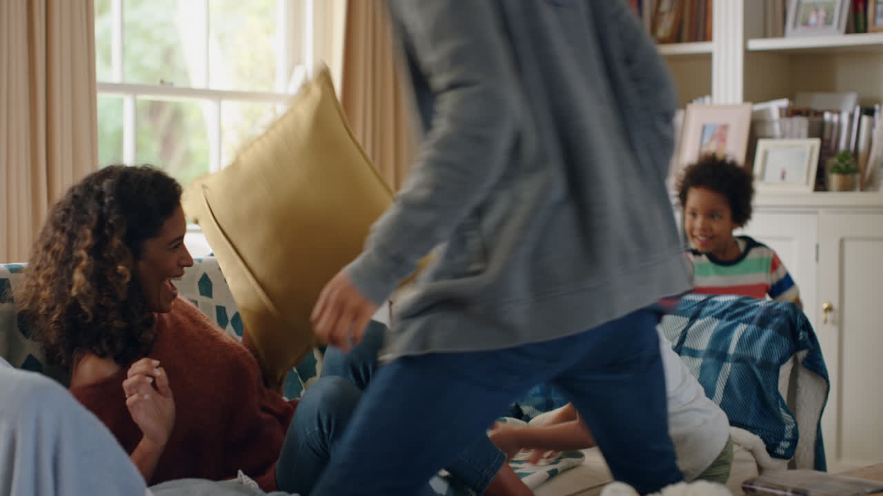 행복 한 가족 은 베개 싸움 을 하고 있으며, 어머니 와 아버지 는 집 에서 자녀 들 과 함께 놀고 주말 에 함께 즐기고 있다