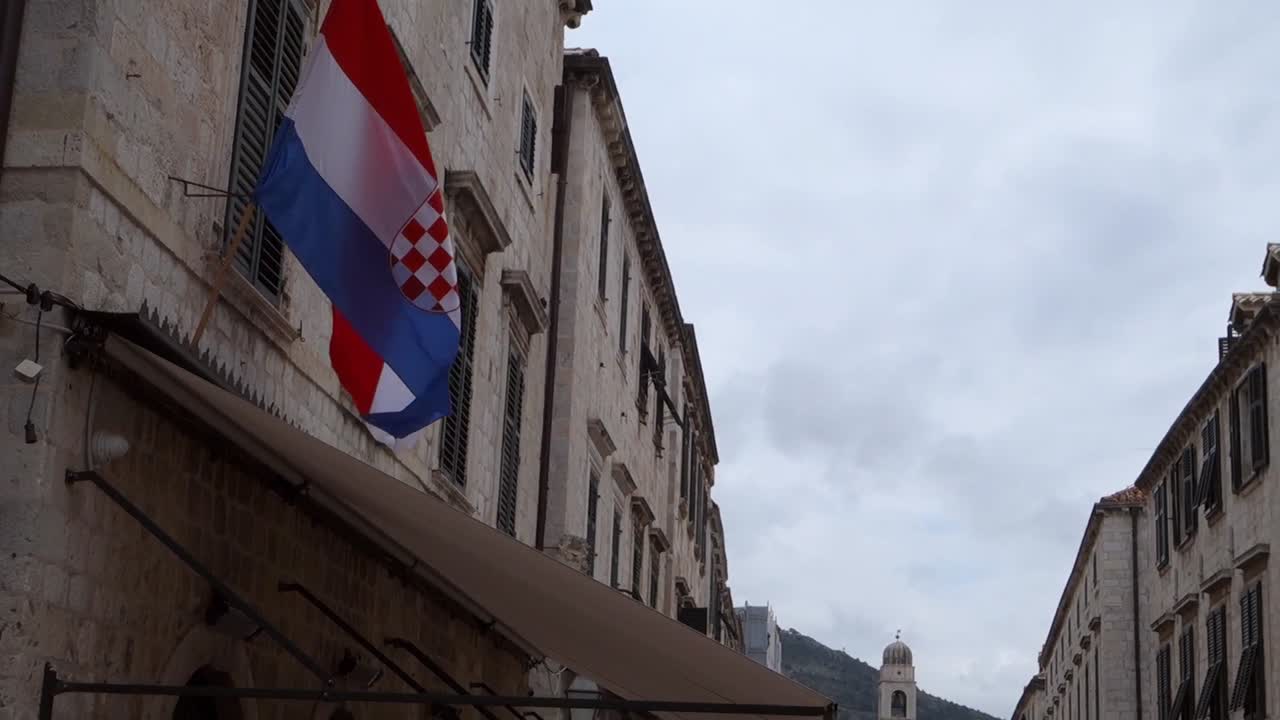 Croatian flag waving in slow motion on the facade of an old building