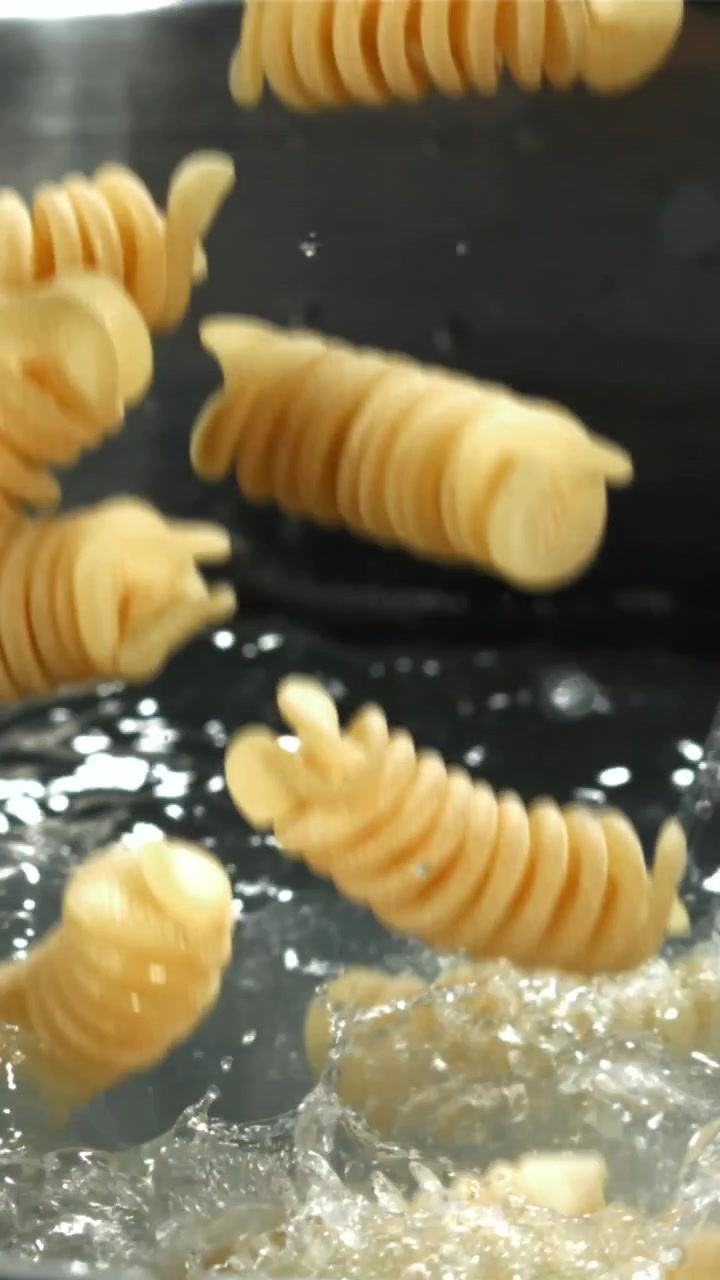 Fusilli Pasta Falling into Boiling Water in Slow Motion