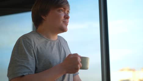 man drinking coffee by the window