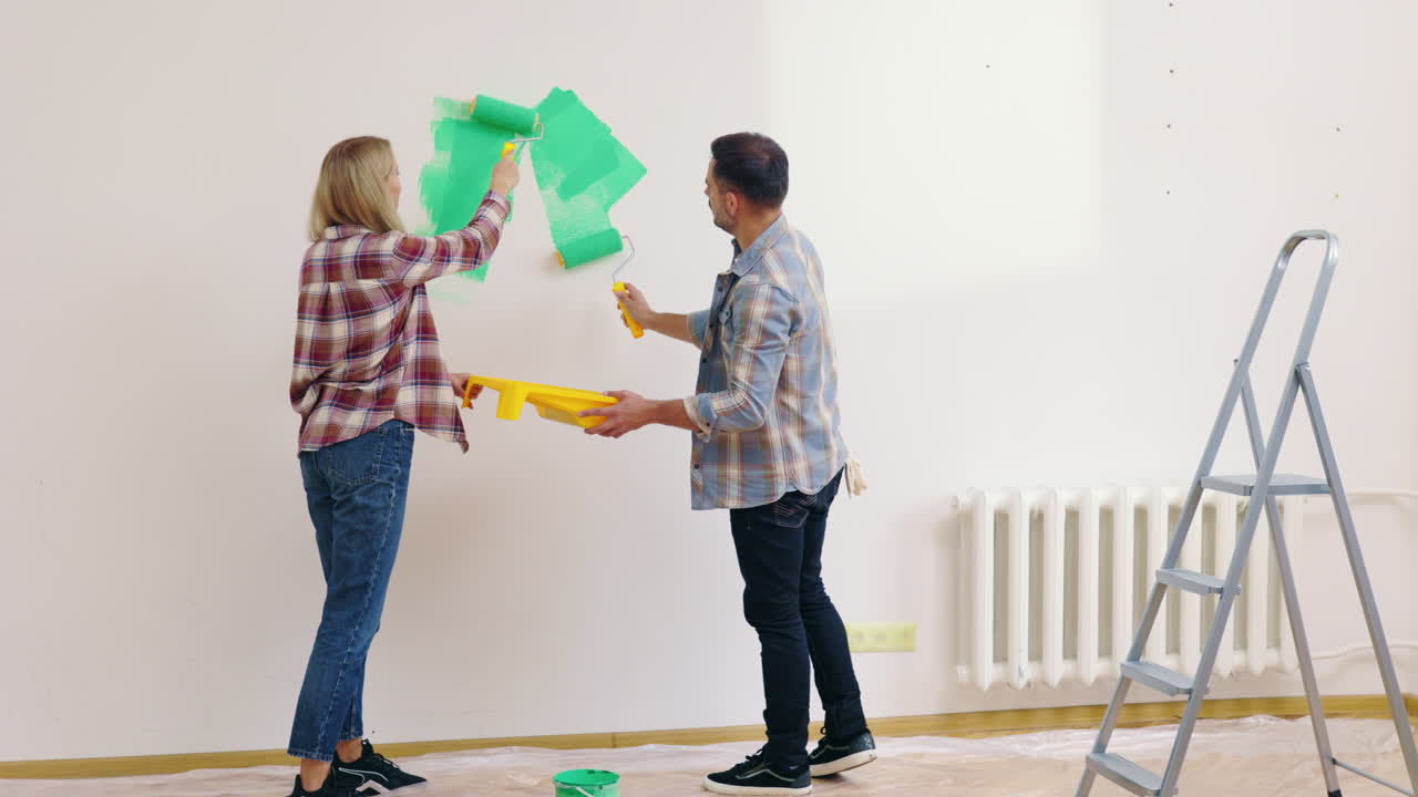 Couple Painting a Wall Green