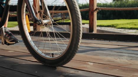 a person riding a bicycle across a wooden bridge in a park