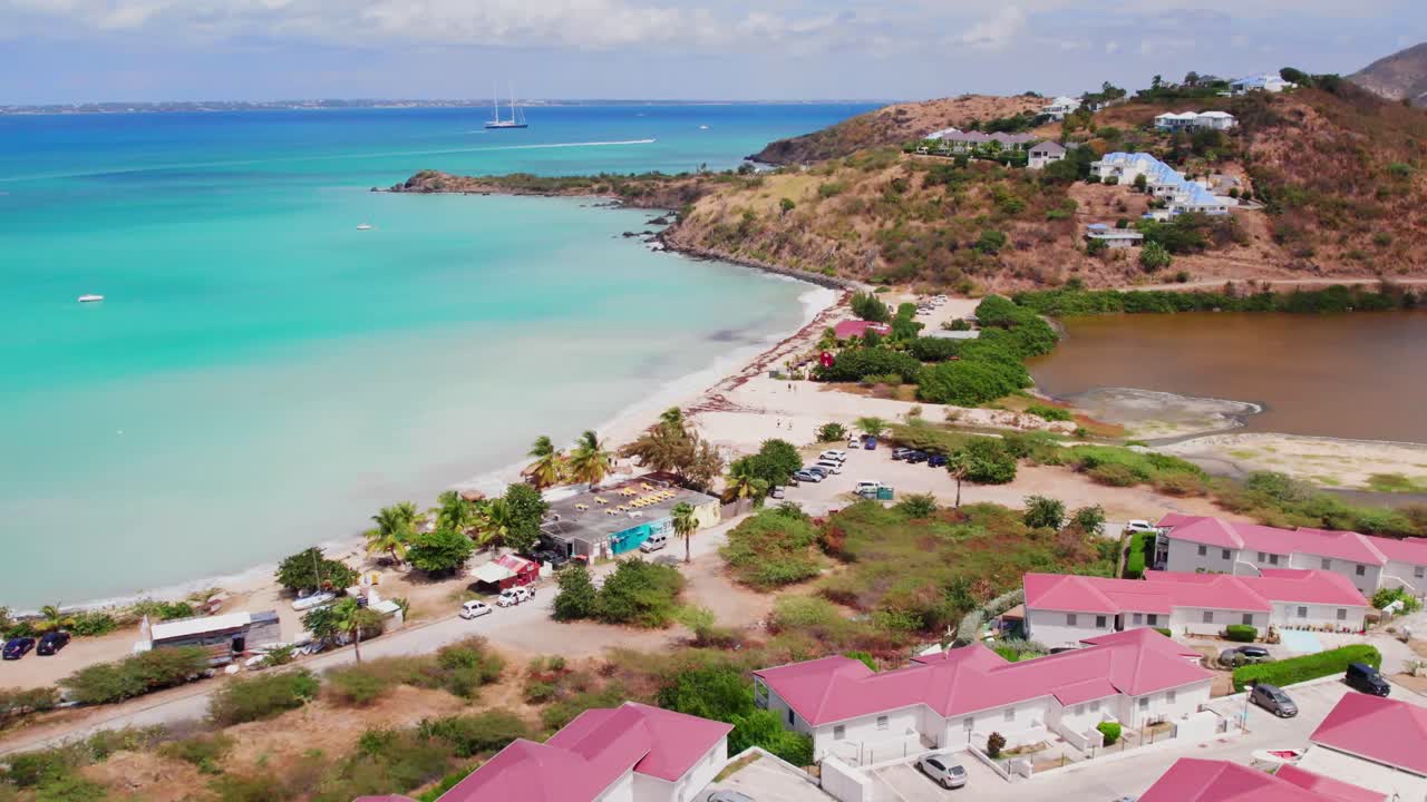 Saint Martin'in palmiyelerle çevrili kumlarının üzerinde süzülüyor