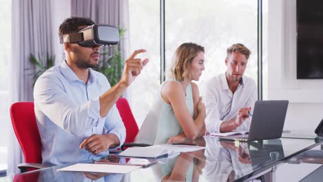 professional businesswoman using virtual reality headset while sitting in office in slow motion